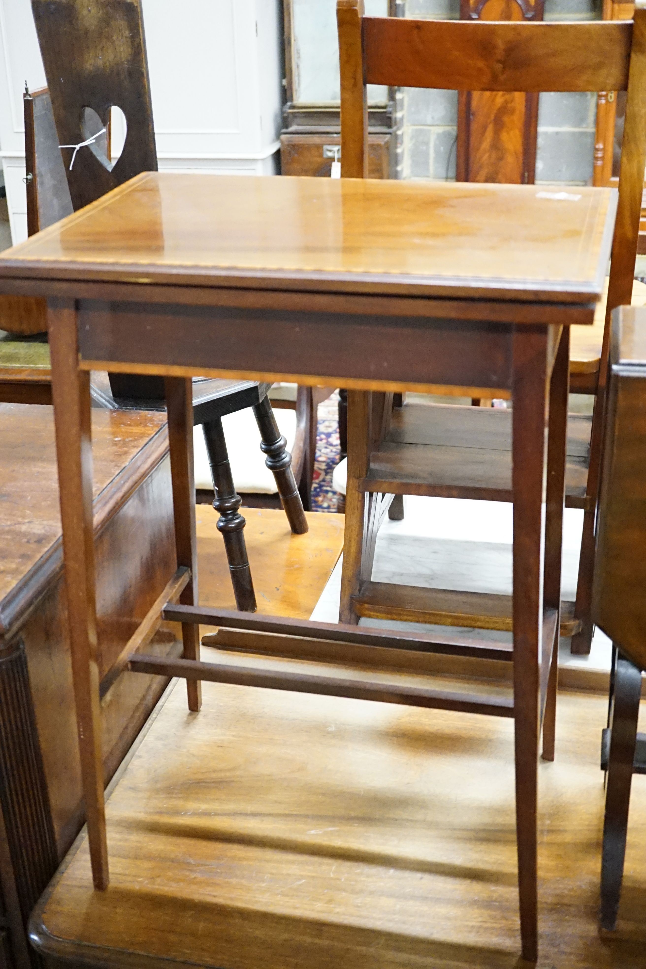An Edwardian banded mahogany fold-over top table, 51 cm wide, 36 cm deep, 71.5 cm high and a mahogany Sutherland table